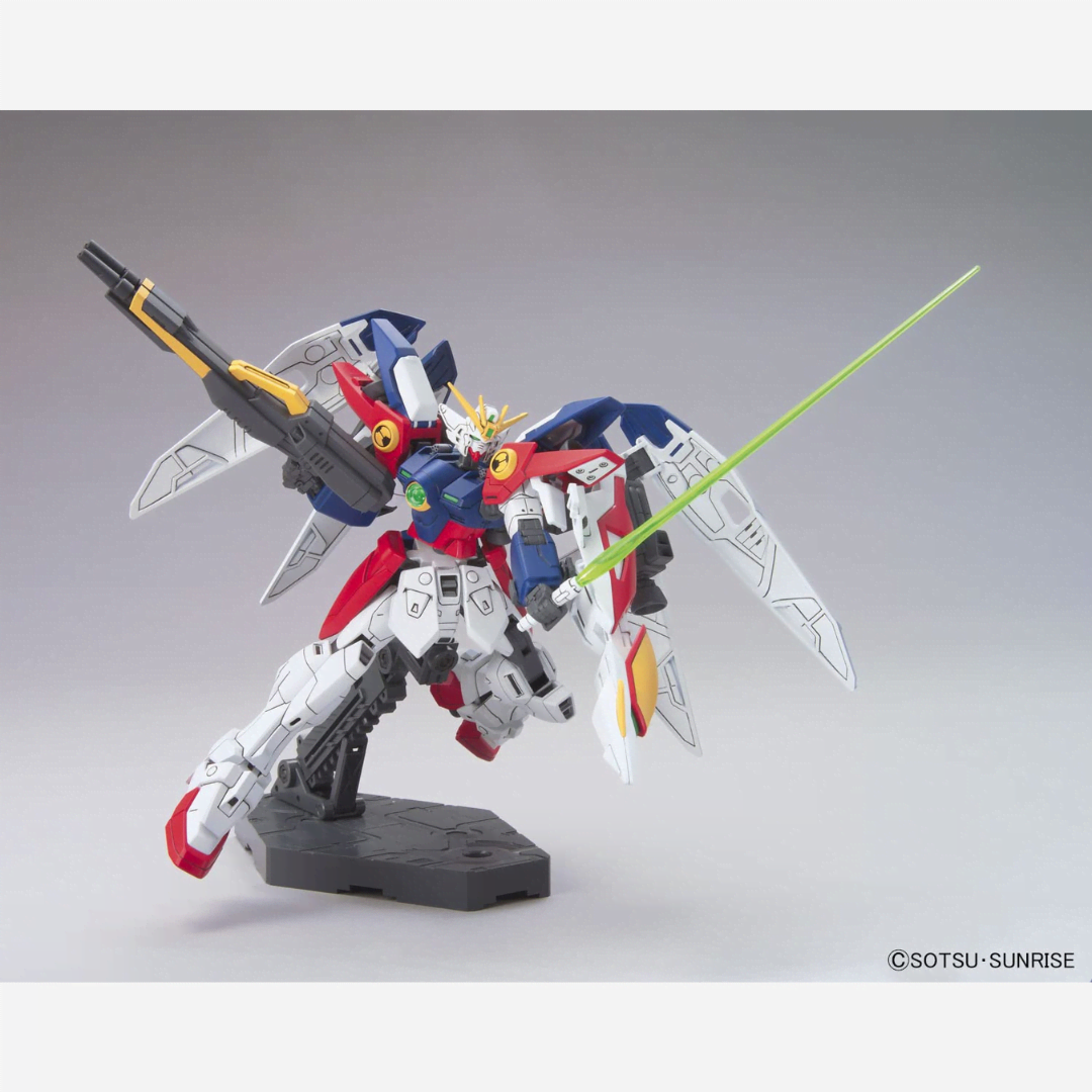Box model kit HG 1/144 Wing Gundam Zero Bandai con Buster Rifle e ali spiegate in posa dinamica da battaglia tratto da Gundam Wing