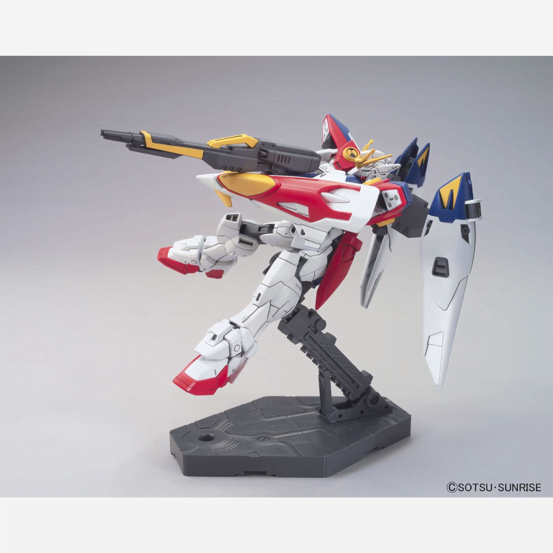 Box model kit HG 1/144 Wing Gundam Zero Bandai con Buster Rifle e ali spiegate in posa dinamica da battaglia tratto da Gundam Wing