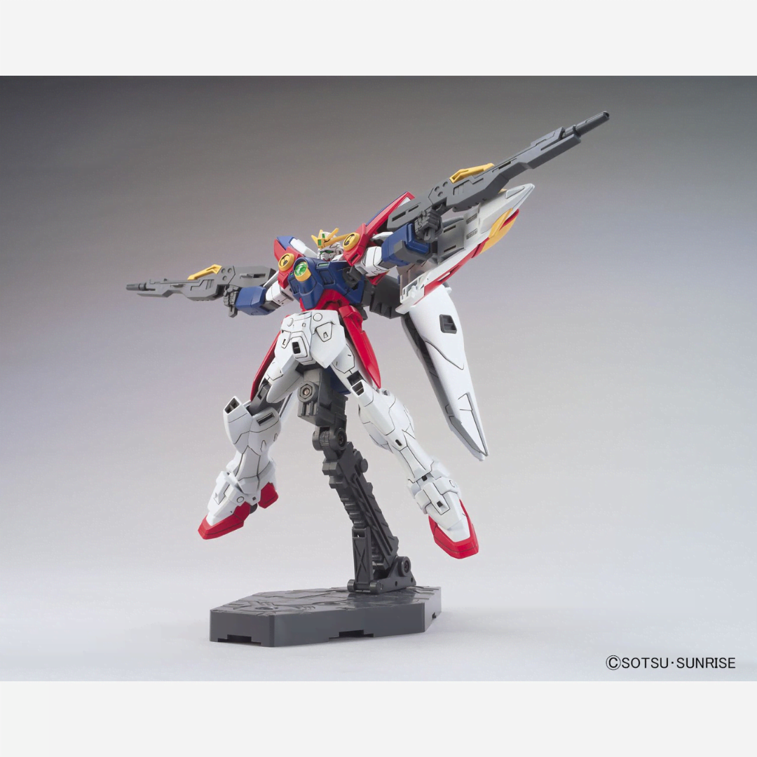 Box model kit HG 1/144 Wing Gundam Zero Bandai con Buster Rifle e ali spiegate in posa dinamica da battaglia tratto da Gundam Wing