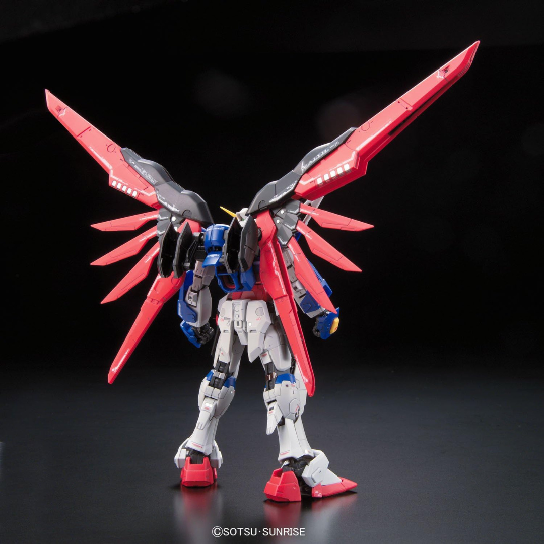 Gunpla RG Destiny Gundam 1/144 Bandai con ali rosse, armi multiple e dettagli dinamici ispirati alla serie Gundam SEED Destiny